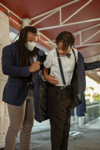 David L. Jackson helps student put on blazer.