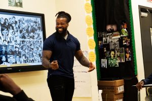 David L. Jackson stands smilig while leading a classroom. 