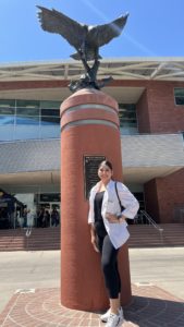 Naidy, California State University LA Peer Leader stands in front of Golden Eagle statue