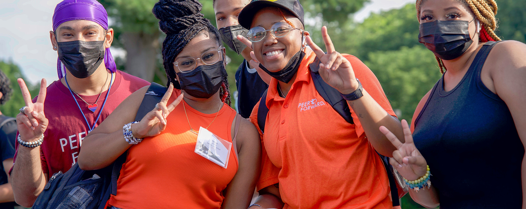 smiling students throw up peace signs at peerforward workshop