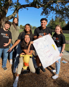 Students pose with a poster on a playground