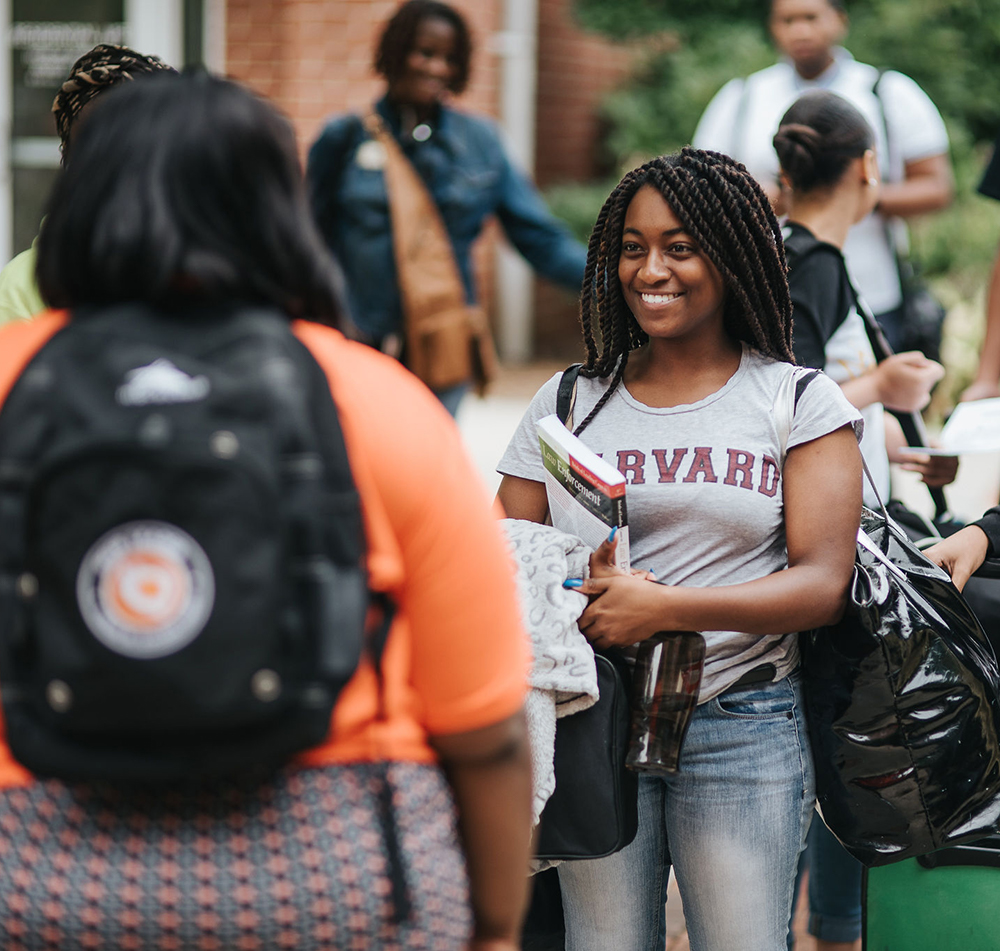 peerforward peer leader in harvard shirt making her way on college campus