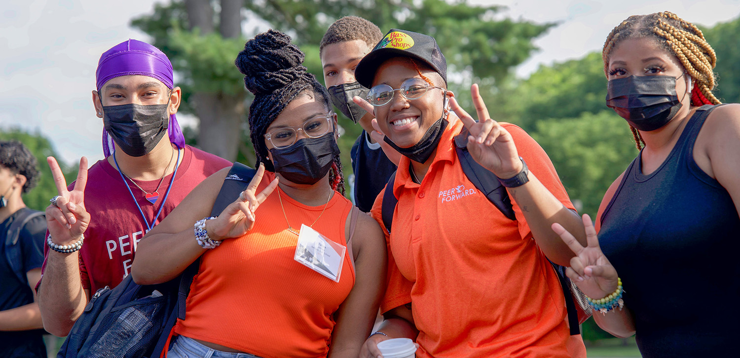 peer leaders throw up peace signs. They're happy and excited.