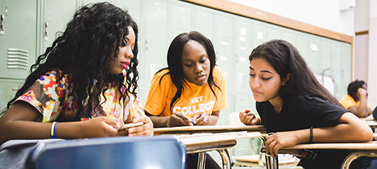 peer forward students look on together at document