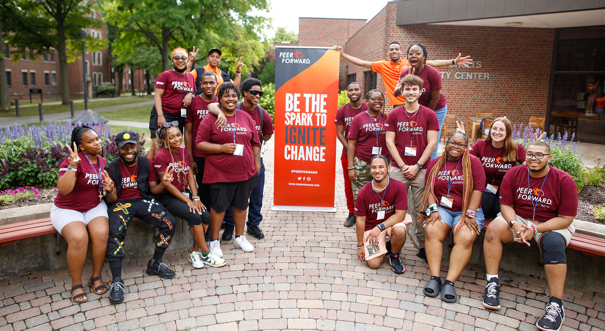 be the spark to ignite change poster and group of excited alumni