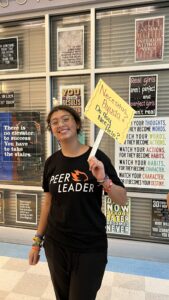 Peer Leader poses with help sign