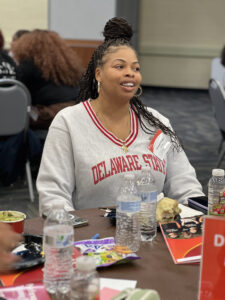 Ahmiyah Mosely sits wearing a Delaware State pullover. 