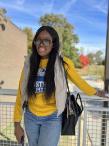 Birizibe Gnassingbe, Deloitte volunteer poses outside of Fall Training Camp